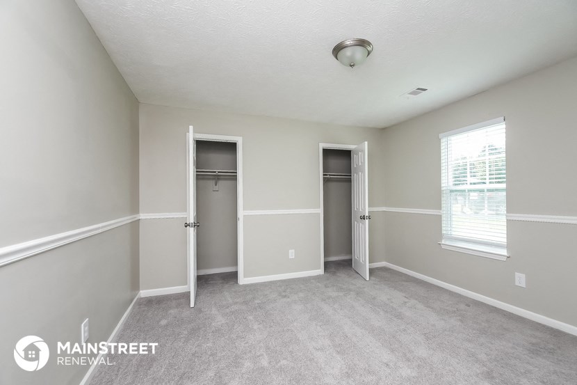 an empty room with two closets and a window