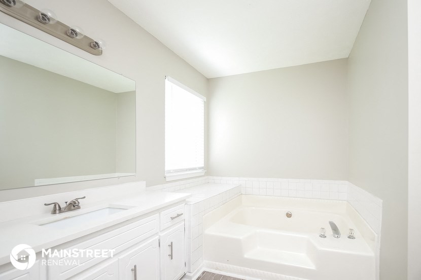 a white bathroom with two sinks and a tub