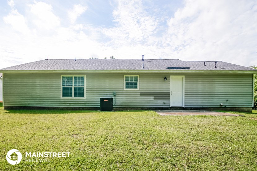 the front of a white house with a grassy yard