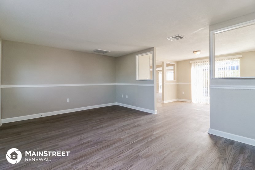 the living room and dining room of an empty renovated house