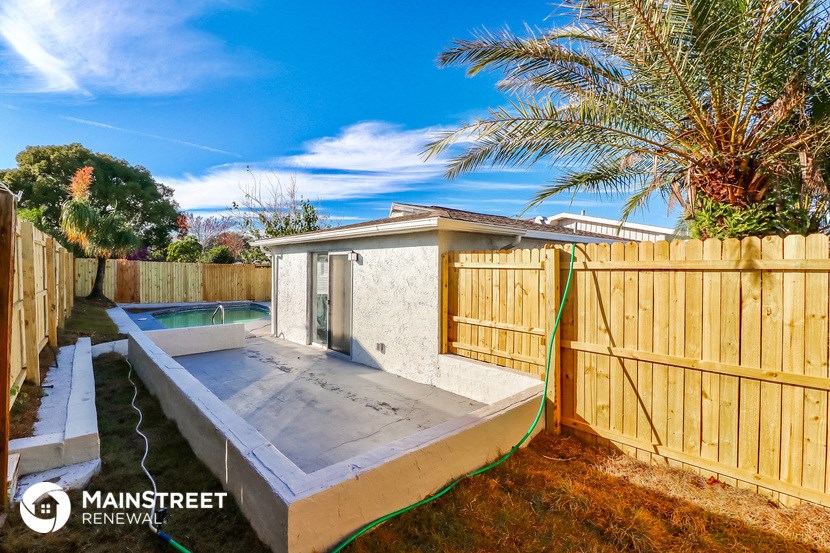 a backyard with a pool and a wooden fence