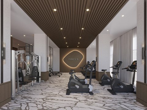 A gym with a variety of equipment including treadmills, stationary bikes, and weight machines.