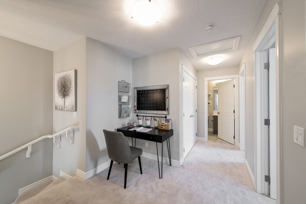 a home office with a desk and a wall mounted tv