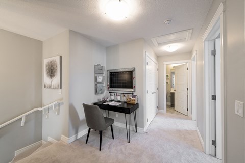 a home office with a desk and a wall mounted tv