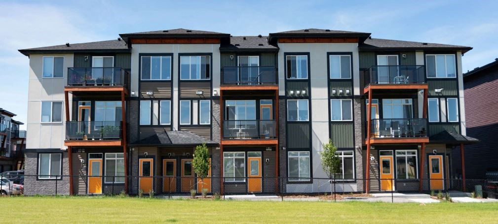 a row of apartments with balconies and a field