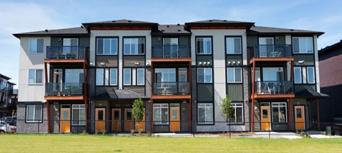 a row of apartments with balconies and a field