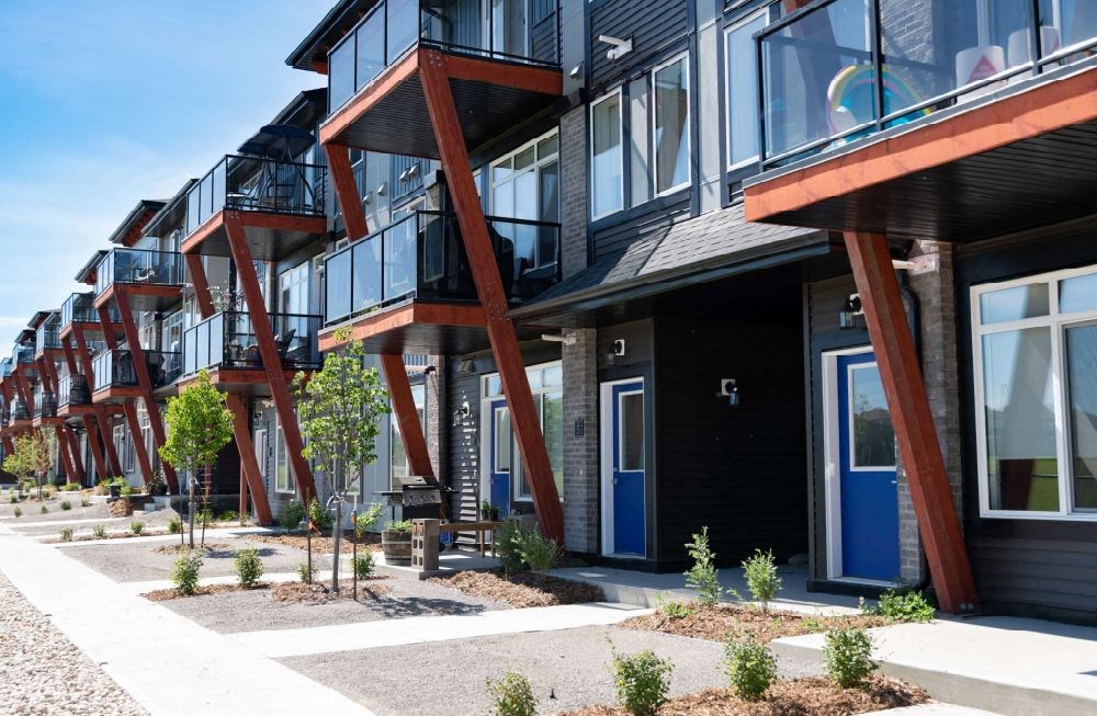 a row of houses with balconies and a sidewalk