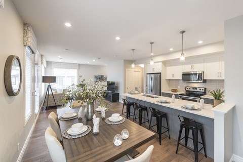 an open kitchen and dining area with a wooden table