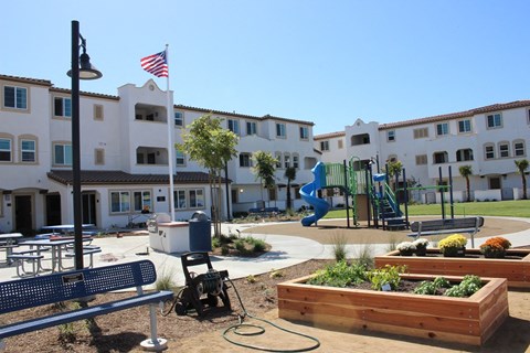 a playground in the courtyard of an apartment complex with a blue slide