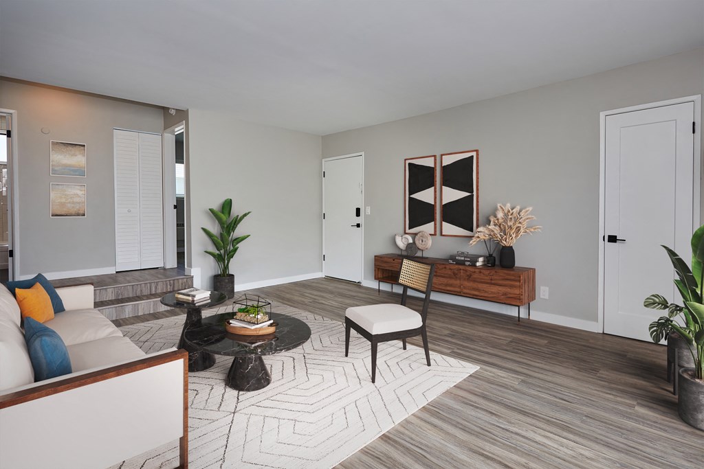 Spacious living room with wooden flooring, light grey walls, and plenty of searing area