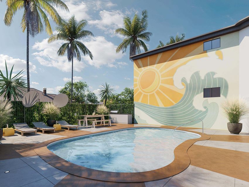 Outdoor pool on a sunny day, surrounded by pool chairs and palm trees - Photo Gallery 1