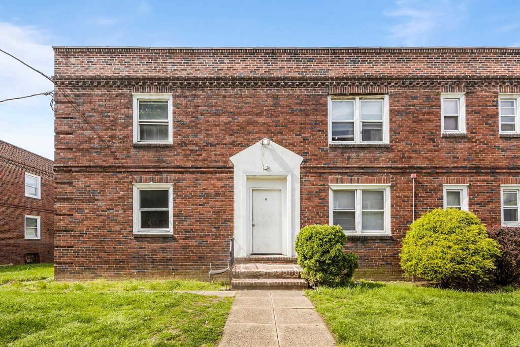 the front of a brick building with a white door
