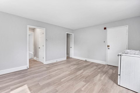 a renovated living room with white walls and wood floors