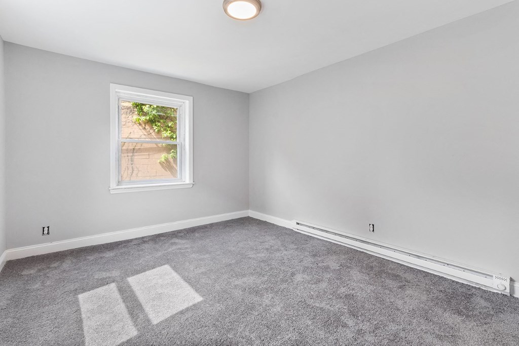 an empty room with carpet and a window