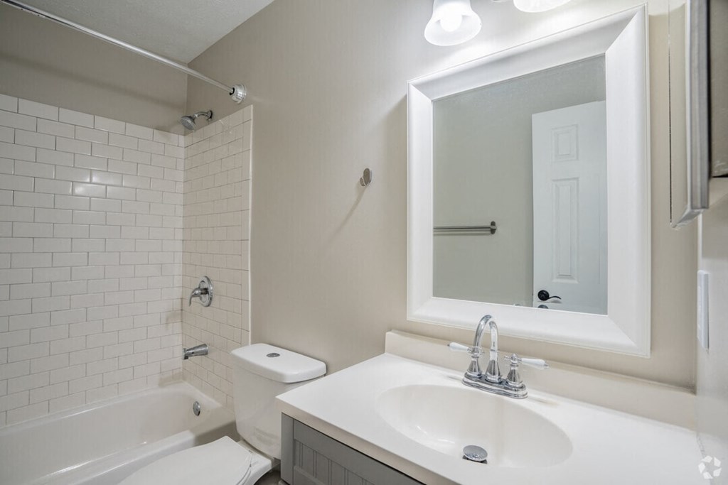 A white bathroom with a sink, toilet, and bathtub.