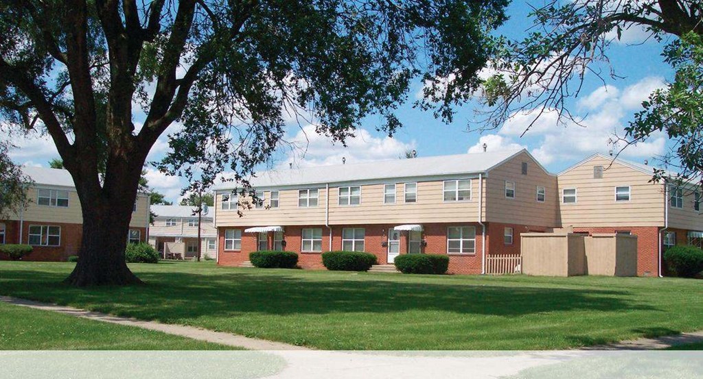 an apartment building with a large tree in front of it