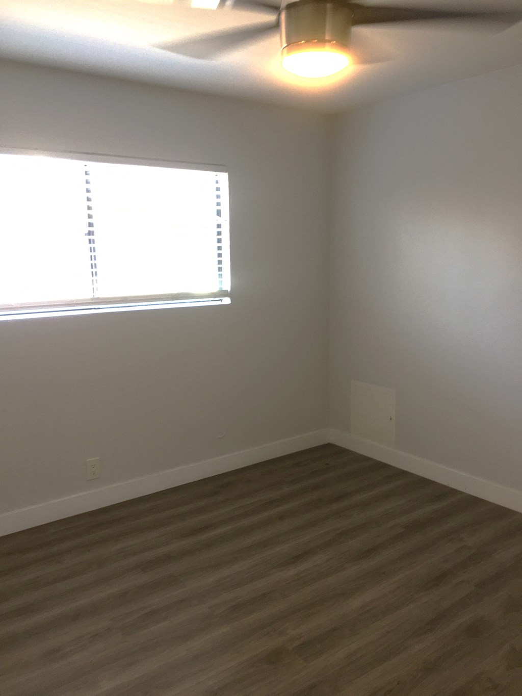 an empty room with wooden floors and a window