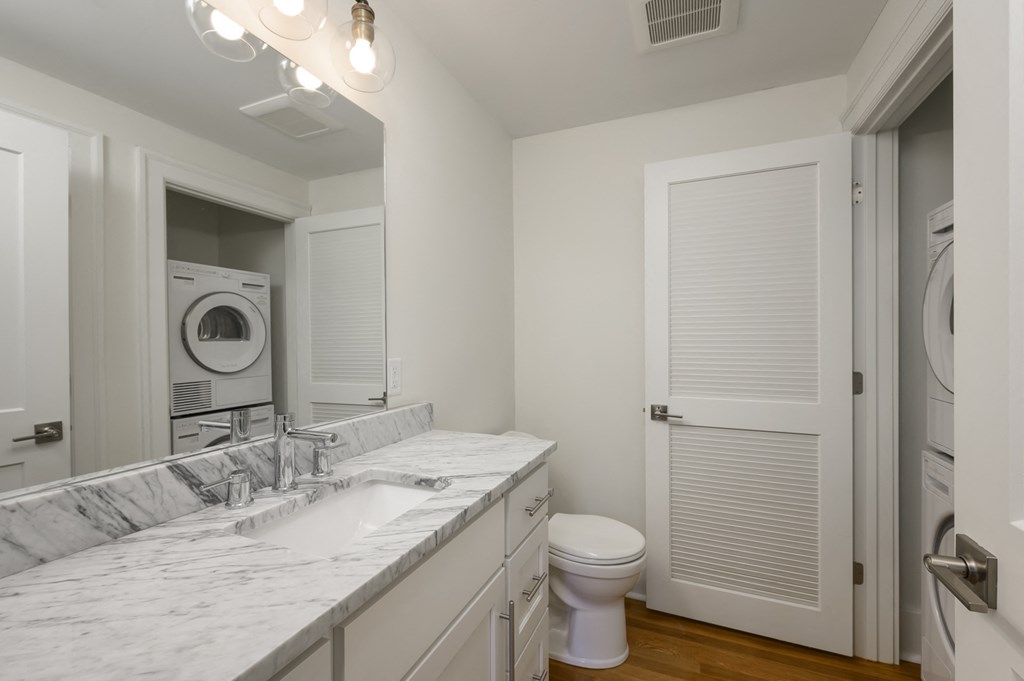 a bathroom with a sink and a toilet and a washing machine