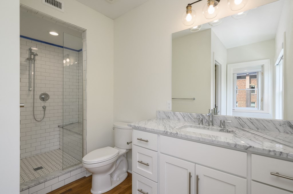 a white bathroom with a shower toilet and sink