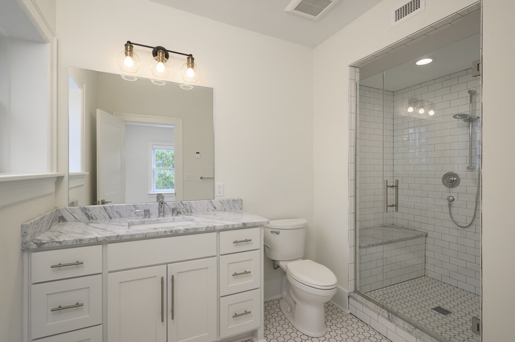 a white bathroom with a shower toilet and sink