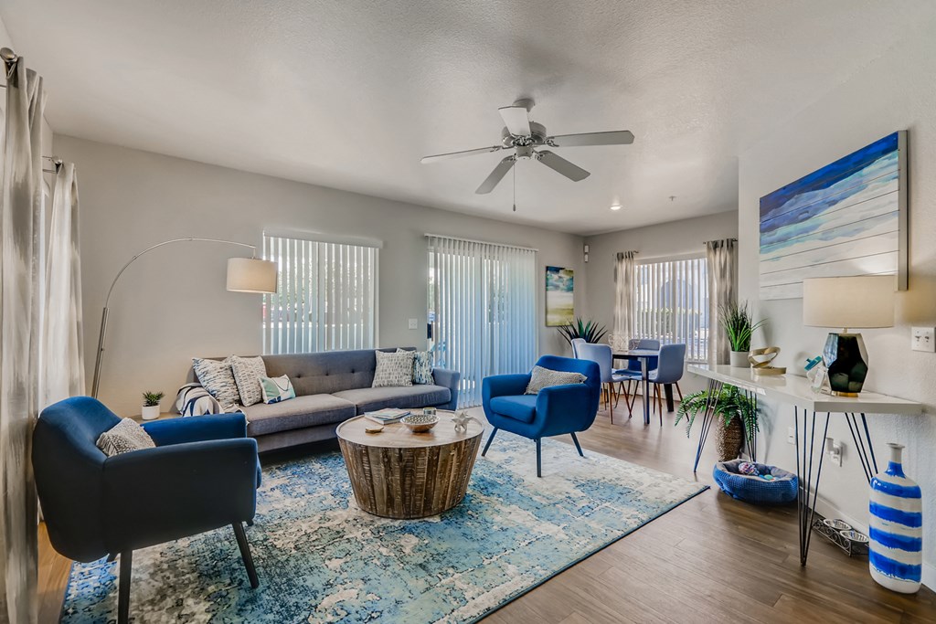 a living room with a couch and chairs and a ceiling fan
