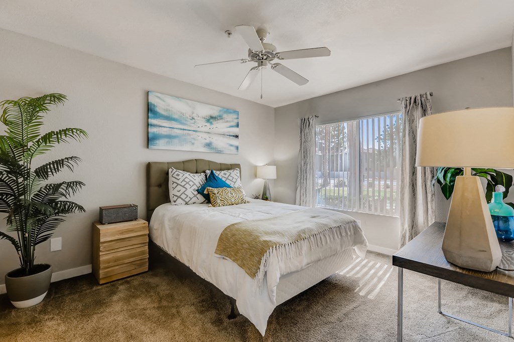 a bedroom with a bed and a ceiling fan