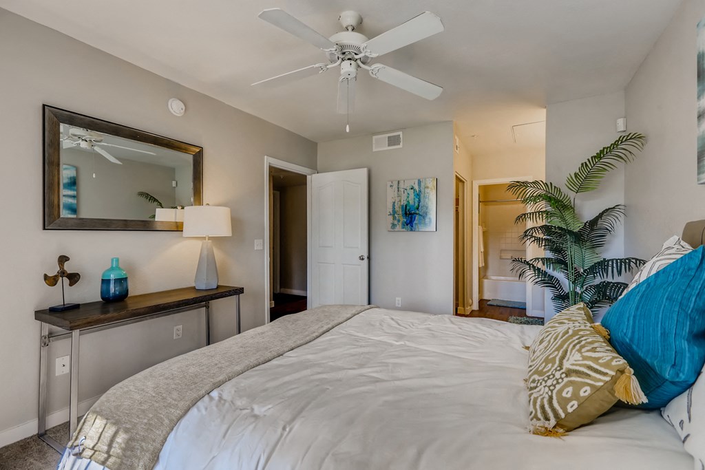 a bedroom with a large bed and a ceiling fan