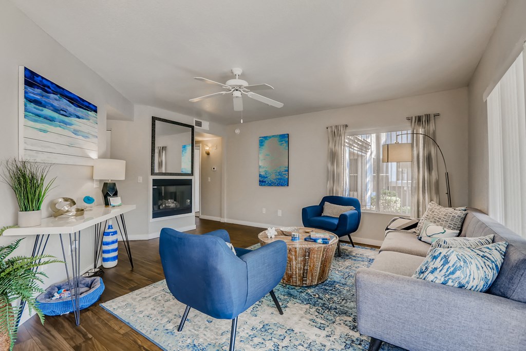 a living room with blue furniture and a ceiling fan