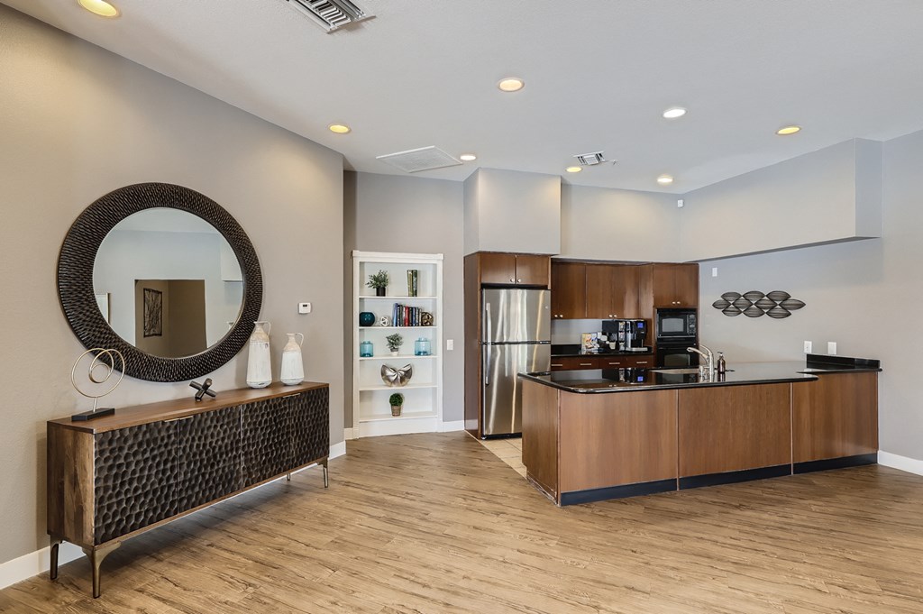 a kitchen and living room with a wooden floor and a stainless steel refrigerator