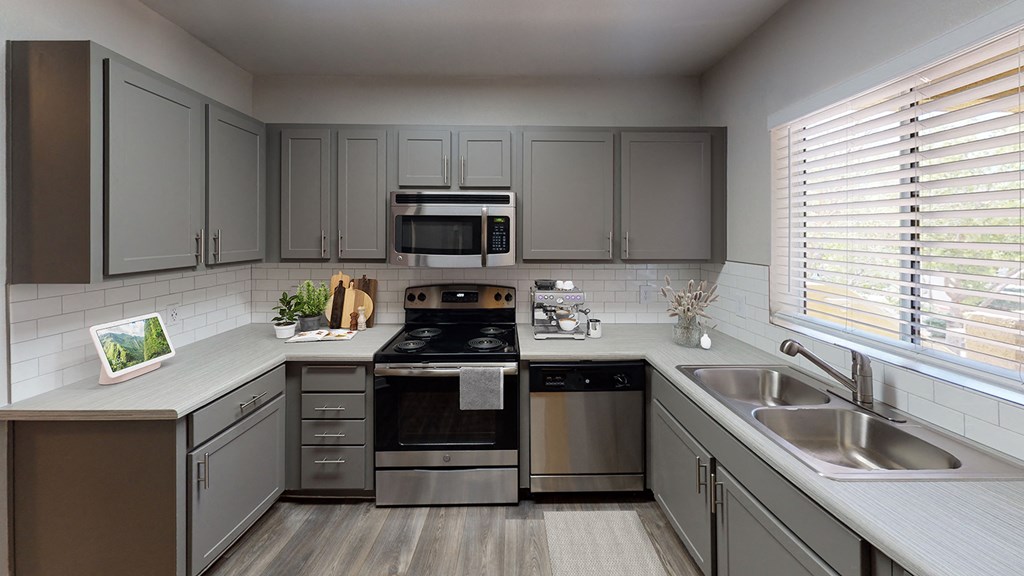 a kitchen with stainless steel appliances and gray cabinets