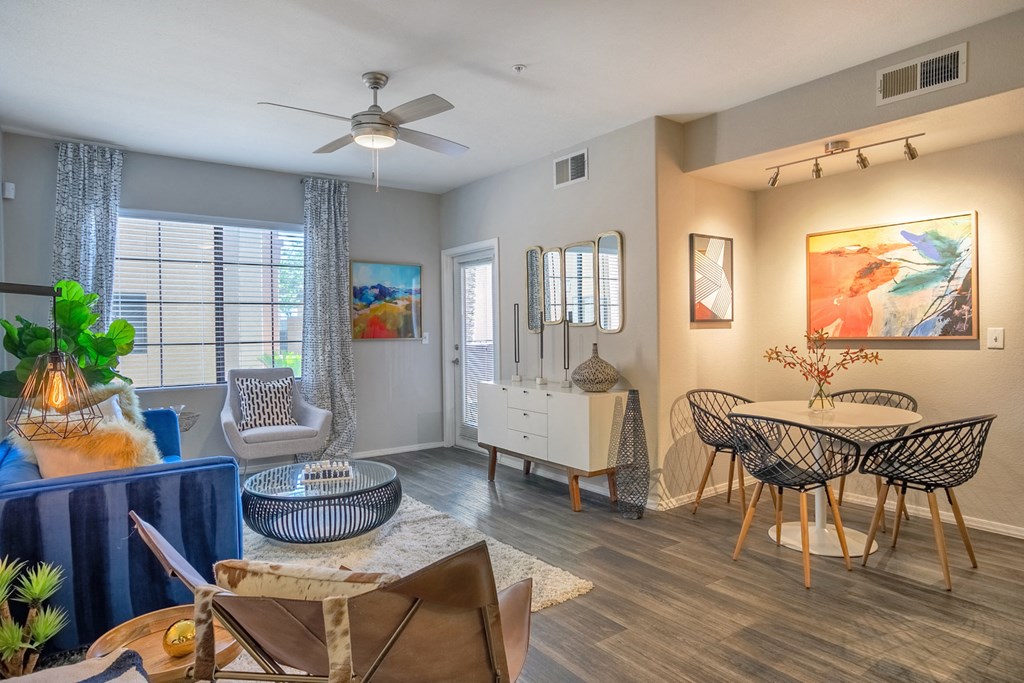 a living room with a table and chairs and a ceiling fan