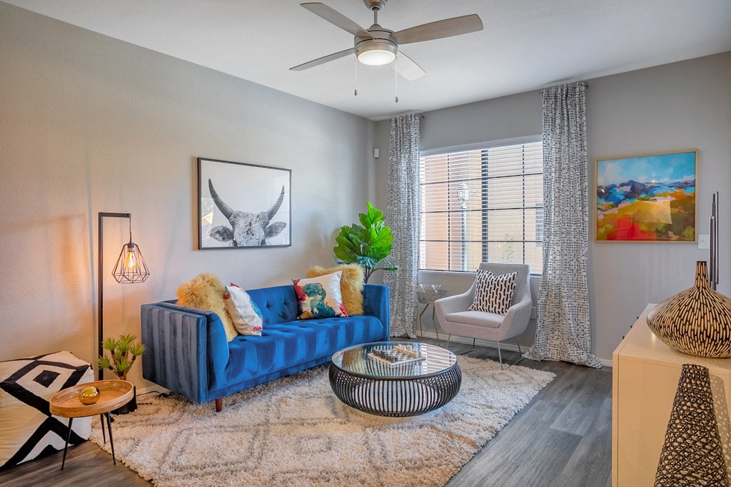 a living room with a blue couch and a ceiling fan
