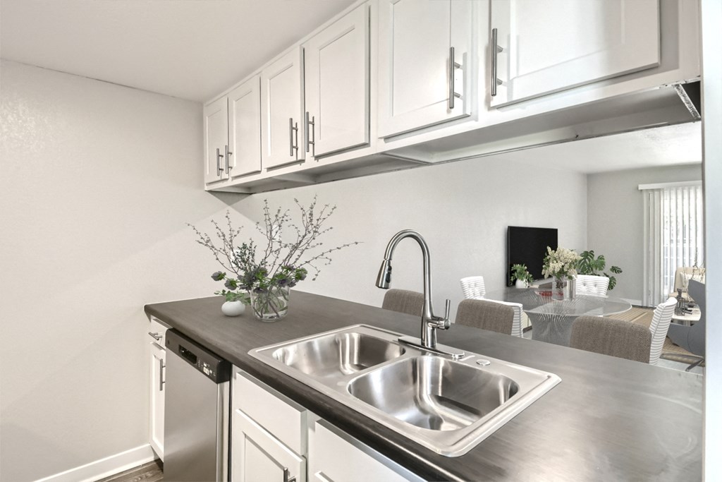 a kitchen with a sink and white cabinets