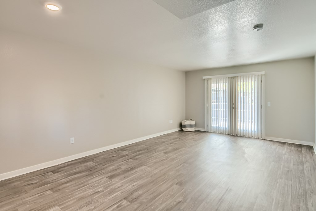 an empty living room with white walls and wood flooring