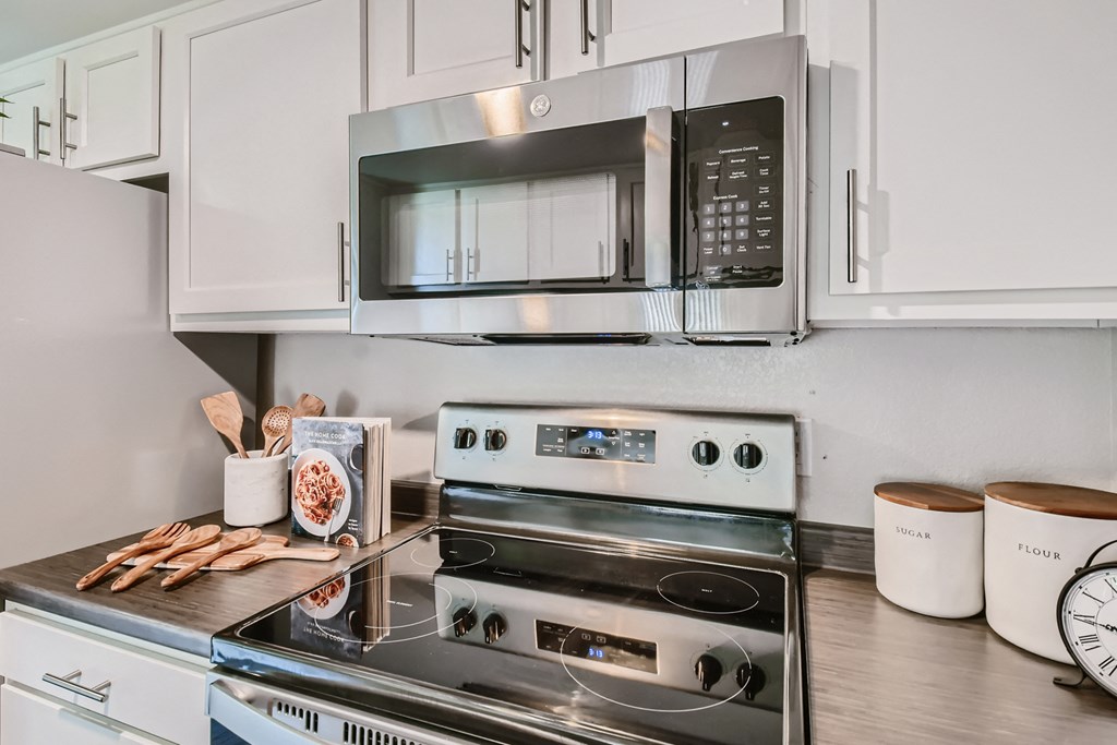 an updated kitchen with stainless steel appliances and white cabinets
