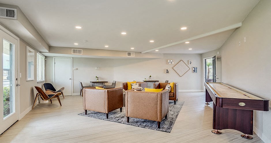 a living room with a pool table and chairs
