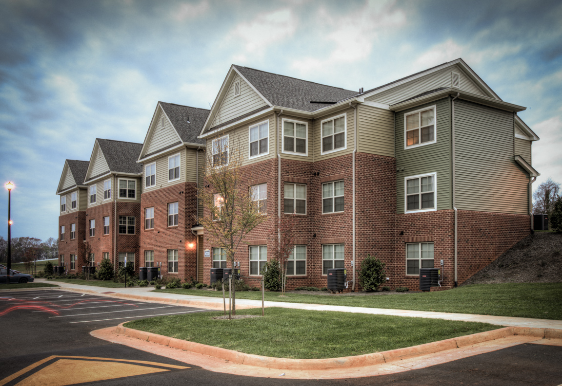 a row of brick apartment buildings on a street corner