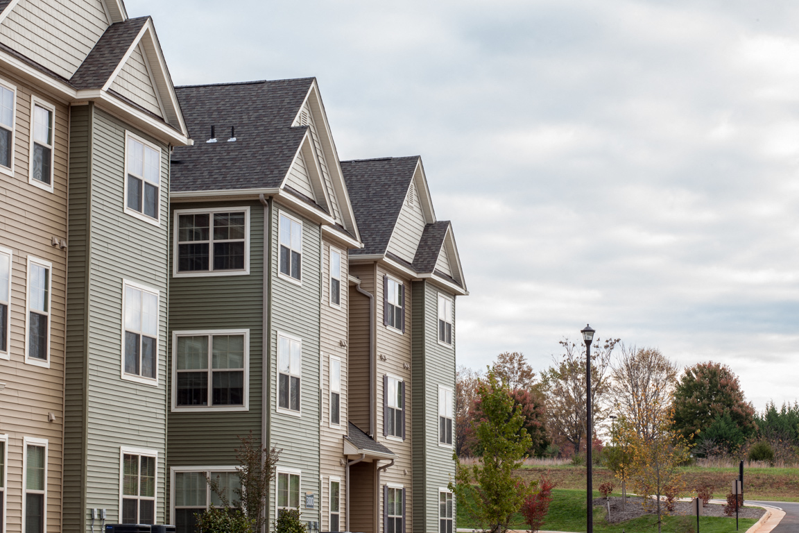 a row of houses in front of a cloudy sky