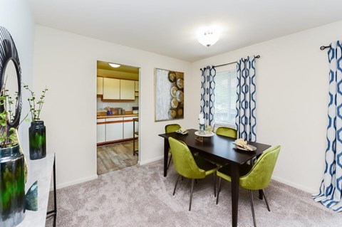 a dining room with a table and chairs and a kitchen