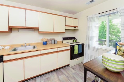 a kitchen with white cabinets and a sink and a window