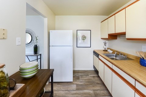 a kitchen with white cabinets and a white refrigerator