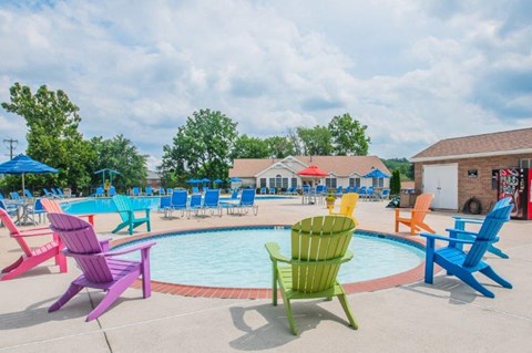 a pool with colorful chairs and chairs around it