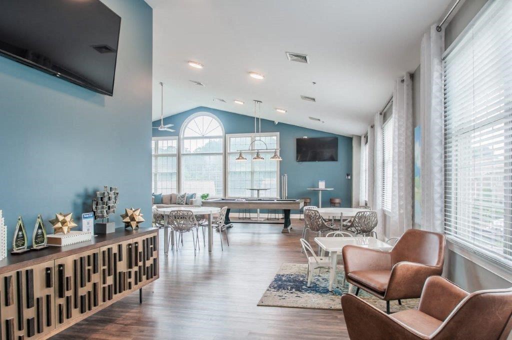 a living room with a pool table and a large window