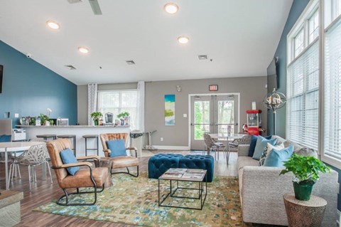 a living room with couches and chairs and a bar