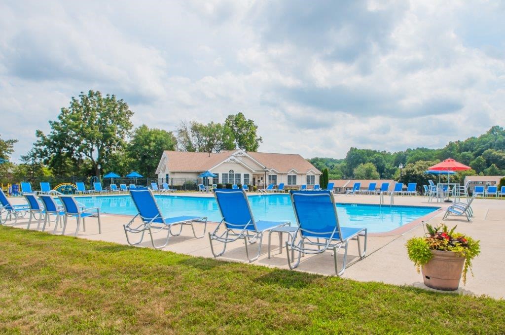 our resort style swimming pool is surrounded by blue lounge chairs