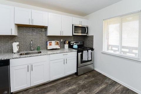 a kitchen with white cabinets and a sink and a microwave