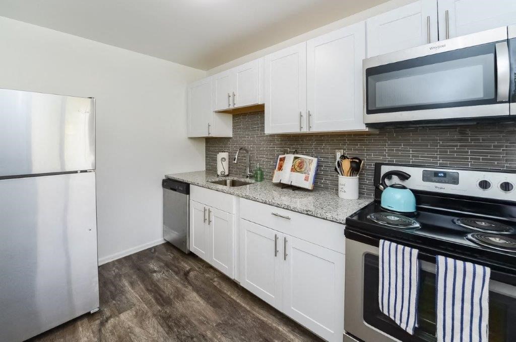 a kitchen with stainless steel appliances and white cabinets