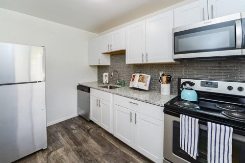 a kitchen with stainless steel appliances and white cabinets