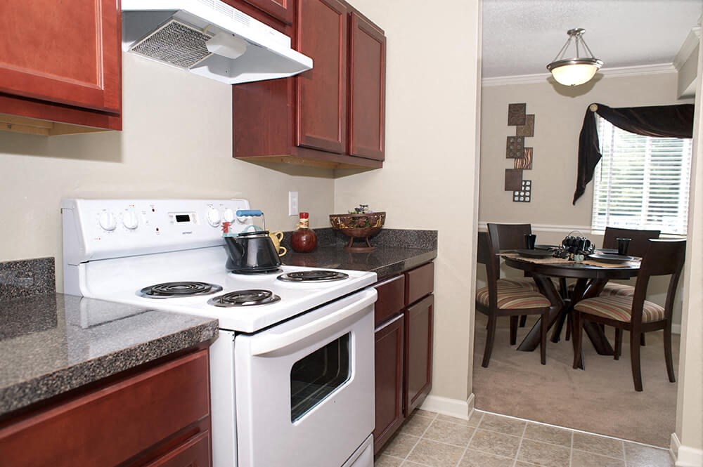a kitchen with a stove and a table with chairs