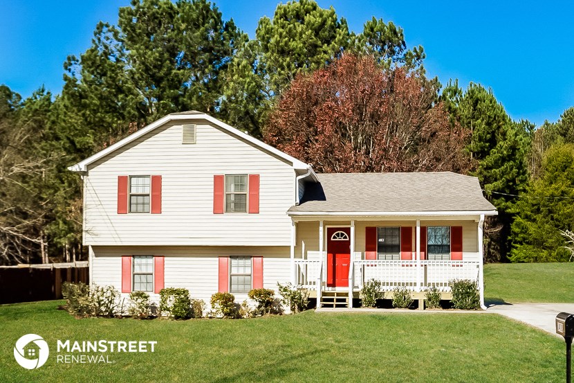 a white house with red shutters and a red door